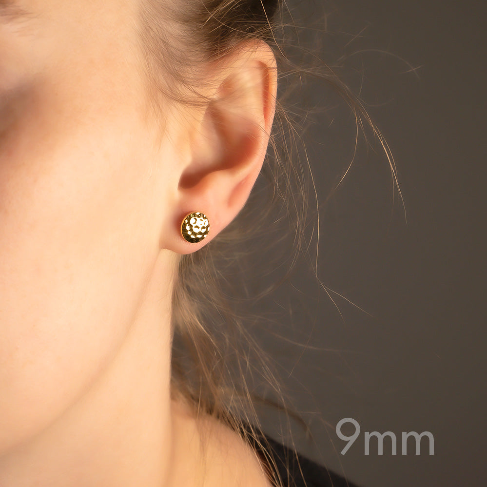 Close-up of a yellow gold vermeil stud earring featuring a sculpted double curved button design, worn on the earlobe for a refined and contemporary look.