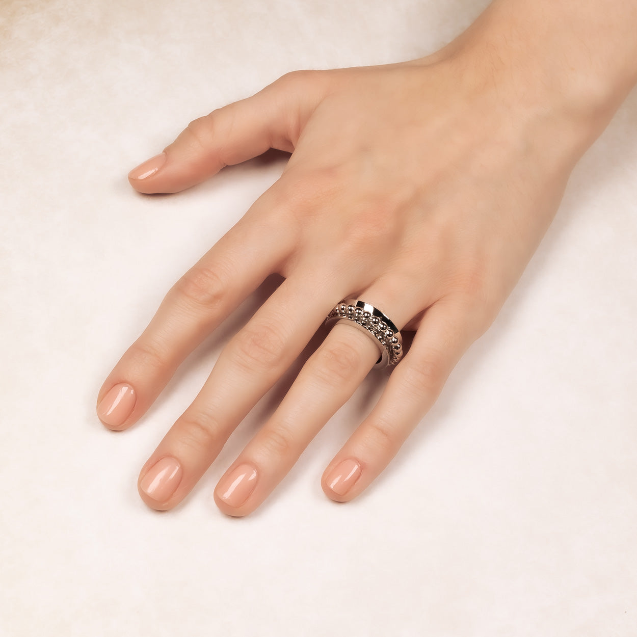 Sterling silver spinning ring featuring polished and beaded textures, worn on the finger to showcase its sculptural, contemporary design in fine silver jewellery.
