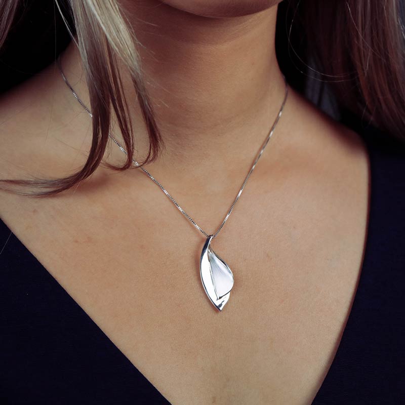 Sleek sterling silver pendant featuring a double leaf design with a smooth, polished finish, suspended from a delicate chain for refined contemporary elegance.