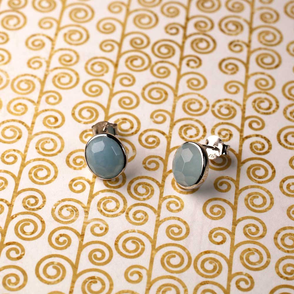 Pair of sterling silver stud earrings featuring faceted aqua chalcedony gemstones set in a polished silver bezel, showcasing a refined and contemporary style.