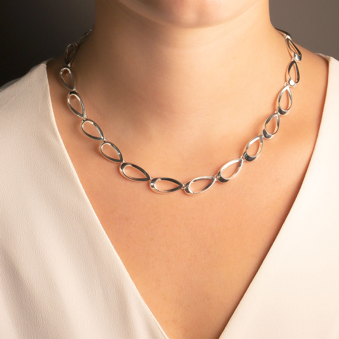 Polished sterling silver necklace featuring a series of smooth, teardrop-shaped links connected to form a sculptural chain, exemplifying refined contemporary silver jewellery.