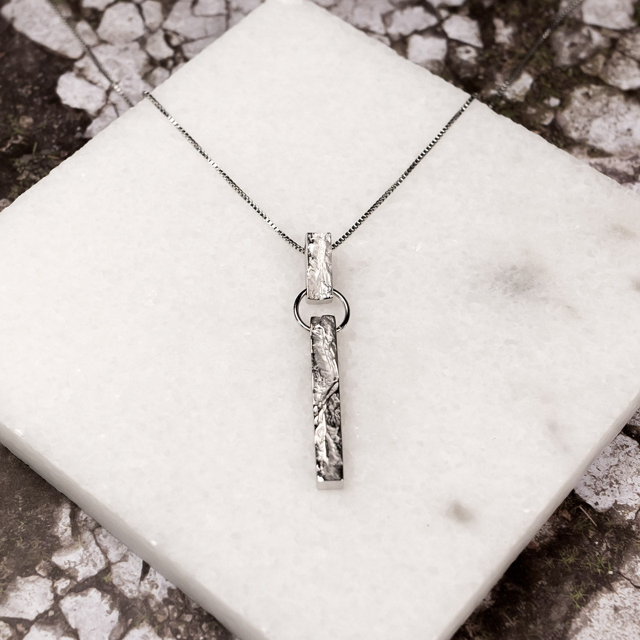Sterling silver pendant featuring a textured bar drop design suspended from a delicate chain, showcasing a contemporary sculptural aesthetic in fine silver jewellery.