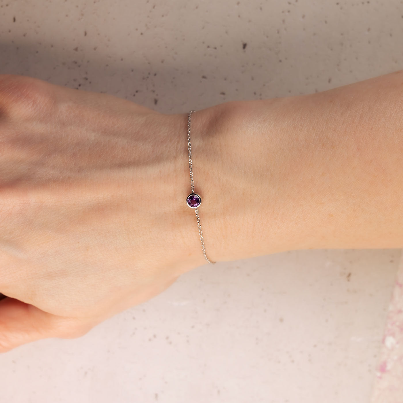 Delicate sterling silver bracelet featuring a single amethyst stone with a fine adjustable chain, embodying elegant British craftsmanship by Azendi.
