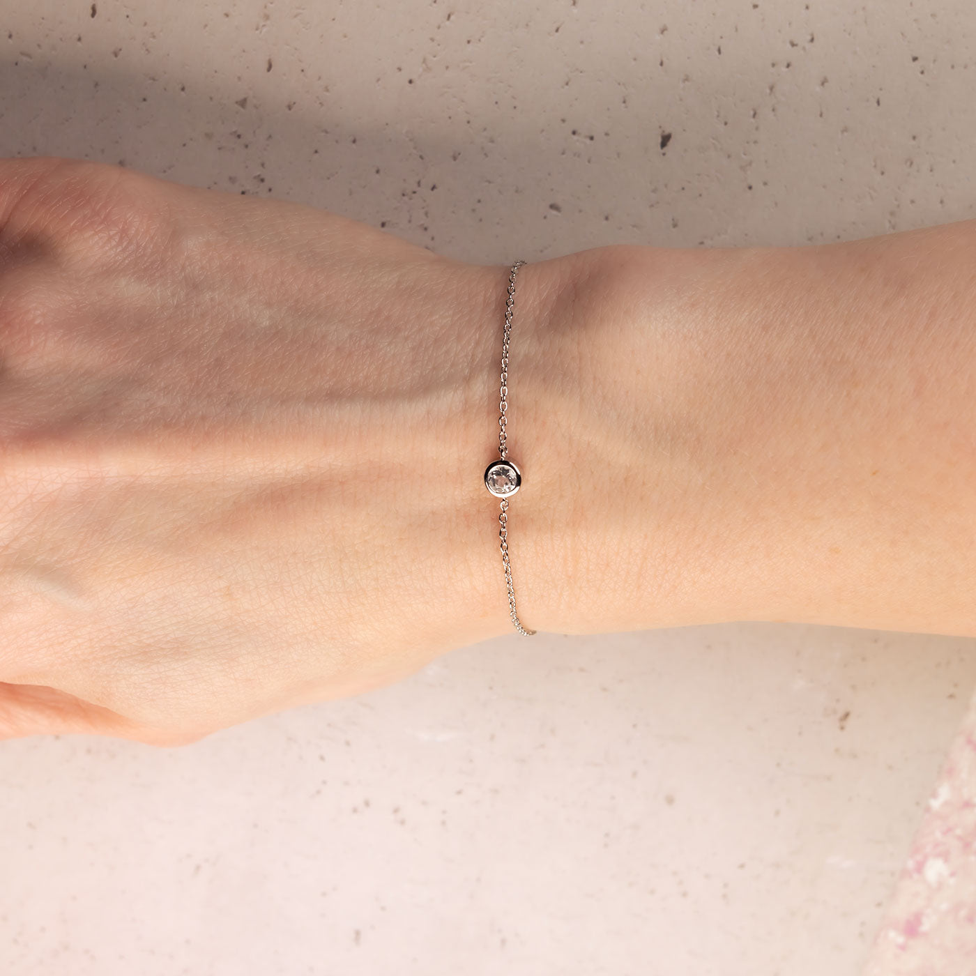 Delicate sterling silver bracelet featuring a single white topaz stone set in a minimalist bezel on a fine adjustable chain, embodying elegant British craftsmanship.