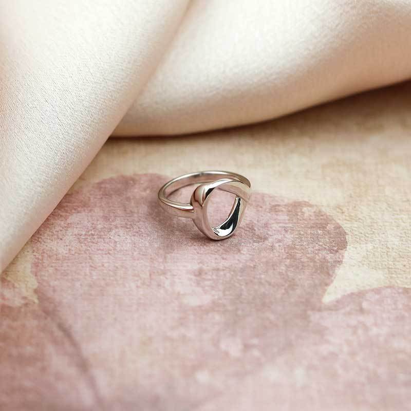 Polished sterling silver ring featuring a sculptural ribbon loop design with a smooth band, exemplifying contemporary elegance in refined silver jewellery by Azendi.